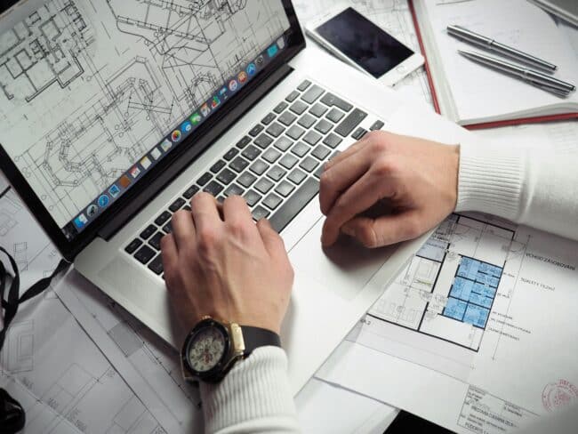 An architect sitting at a computer doing architectural planning and permitting